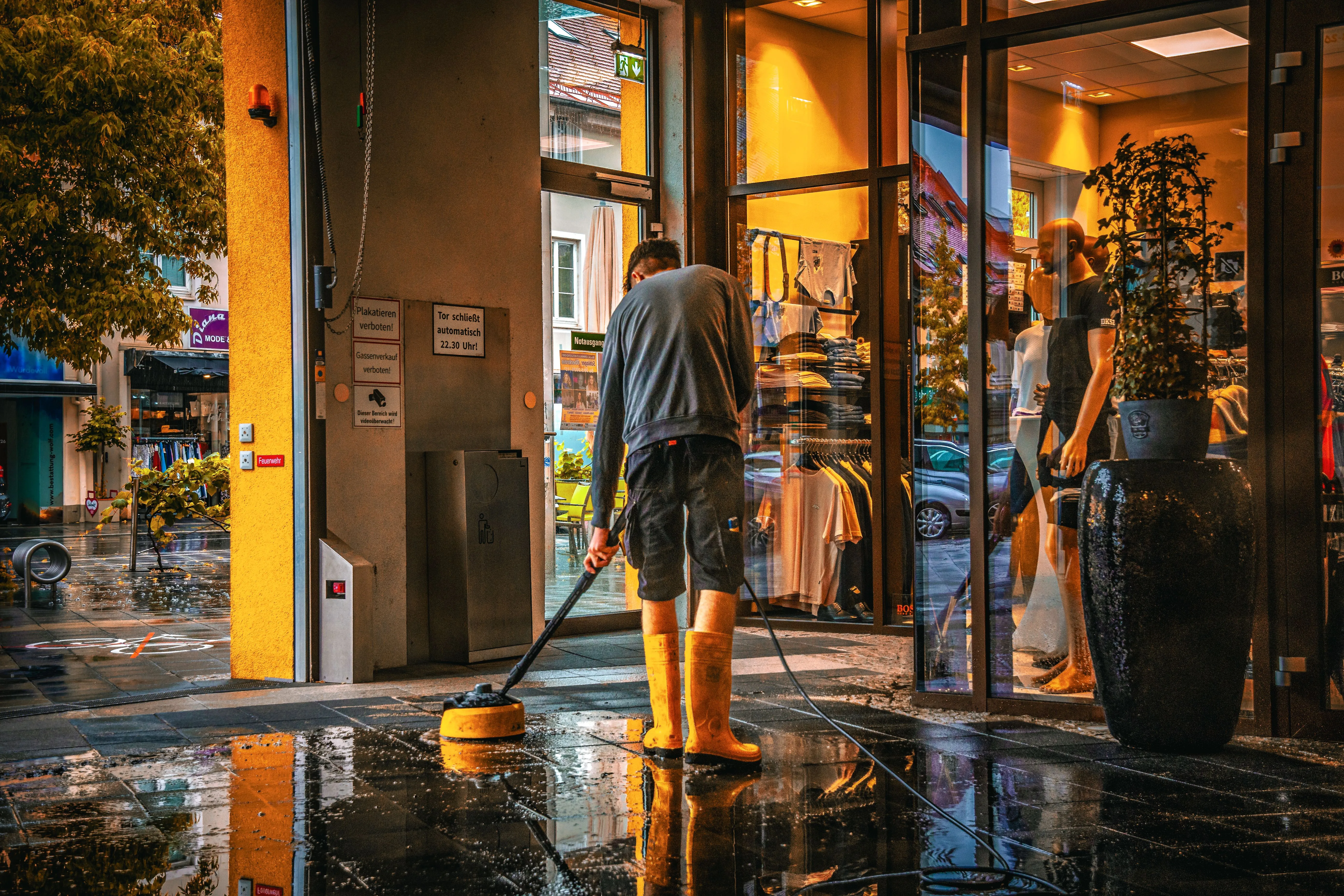 A Lift Shift Shine technician power washing a storefront entrance